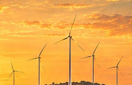 Wind turbines on a ridge at sunset (illustrative)